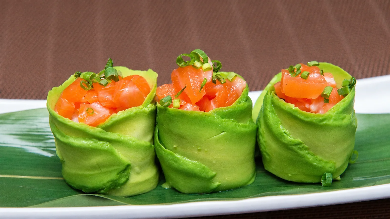 Illustration: Maki on a white plate, on a brown placemat.