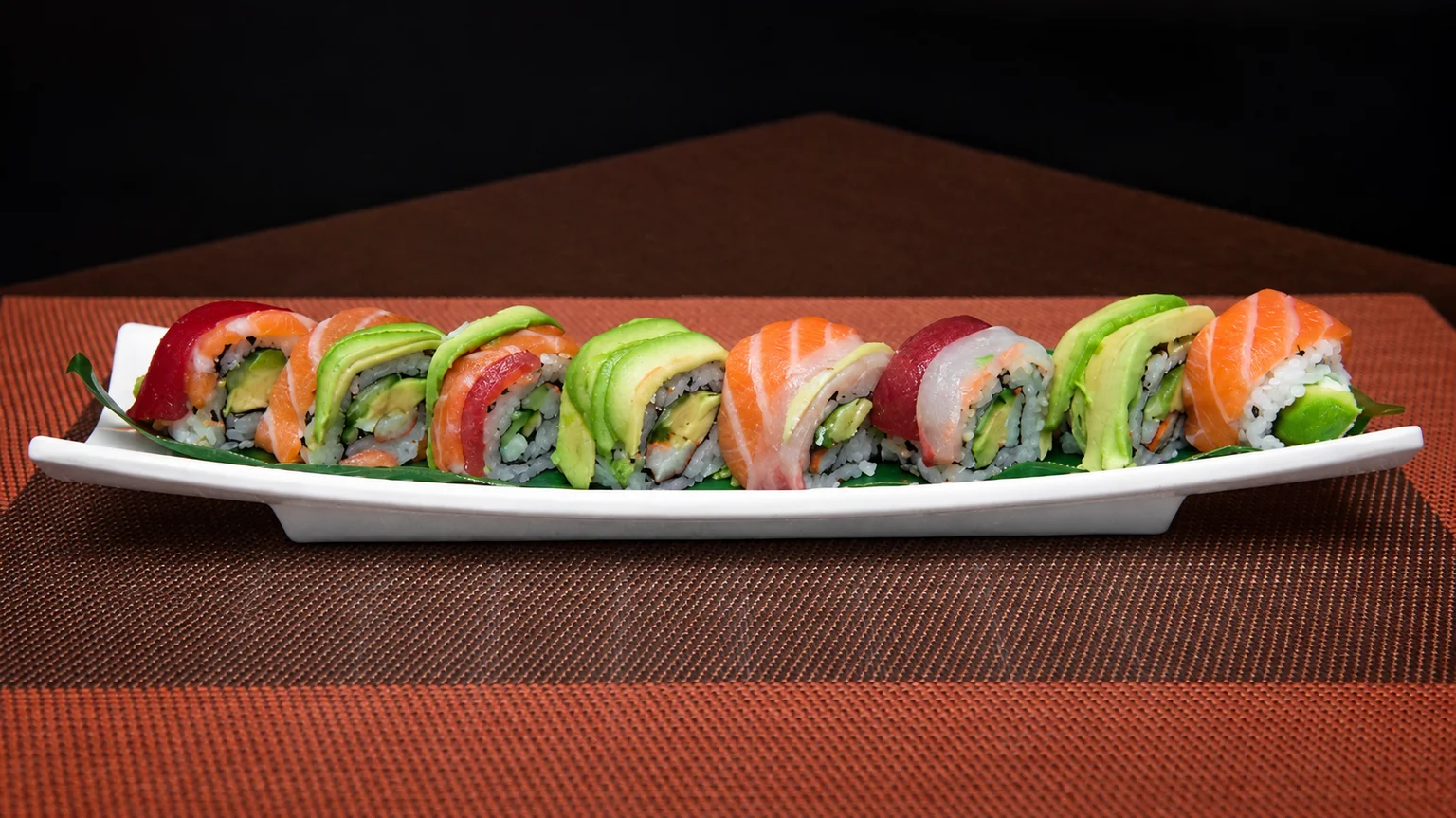Illustration: Maki on a white plate, on a brown placemat.