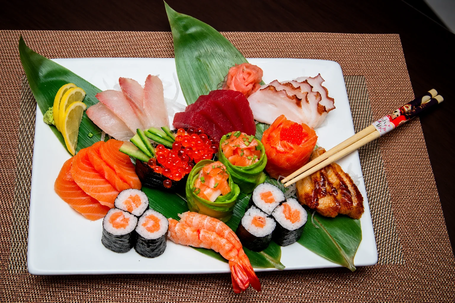 Illustration: Sushi and sashimi on a square white plate.