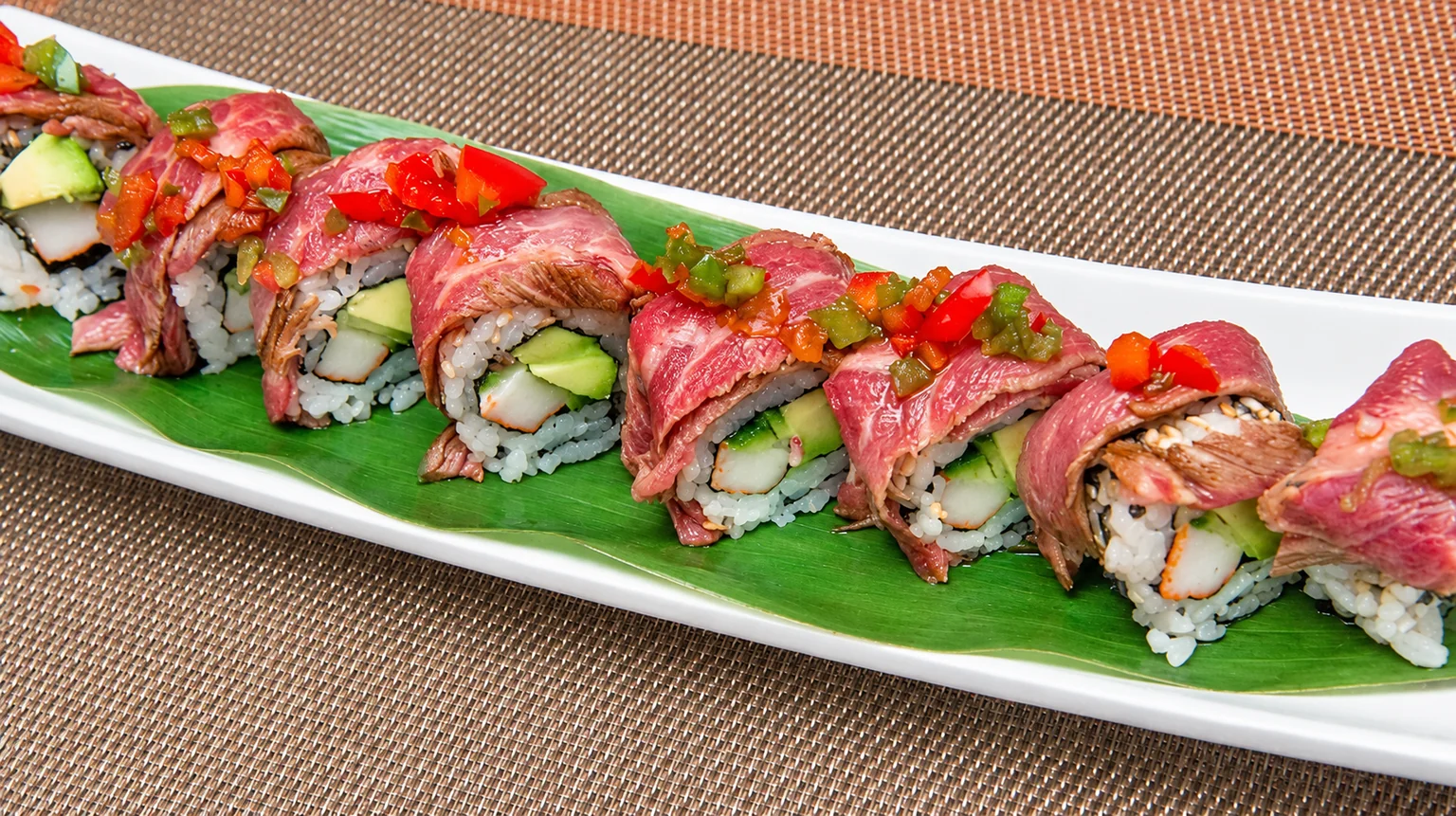 Illustration: Maki on a white plate, on a brown placemat.